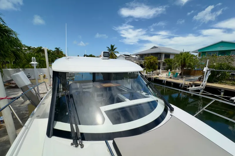 Slide: The Image of 2018 Jeanneau NC 895 docked near waterfront homes under a clear blue sky. - 37
