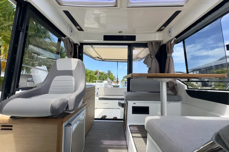 Slide: The Image of Interior of 2018 Jeanneau NC 895 boat with seating and table, showcasing modern design. - 32