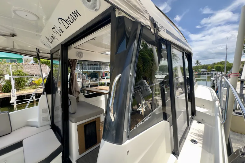 Slide: The Image of 2018 Jeanneau NC 895 boat docked, showcasing sleek design and spacious interior. - 15