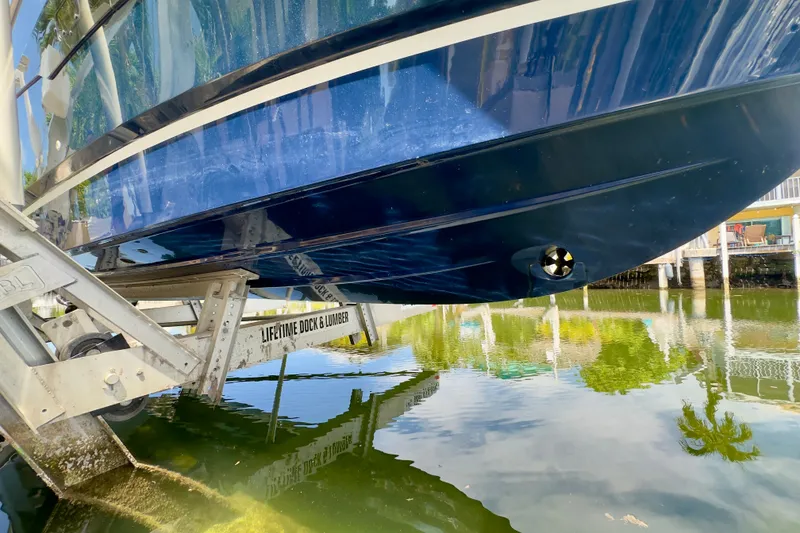 Slide: The Image of 2018 Jeanneau NC 895 boat on lift, reflecting in calm water. - 16