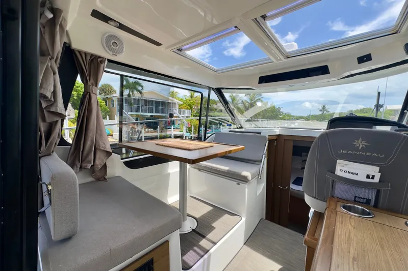 Slide: The Image of Interior of 2018 Jeanneau NC 895 boat with seating, table, and panoramic windows. - 18