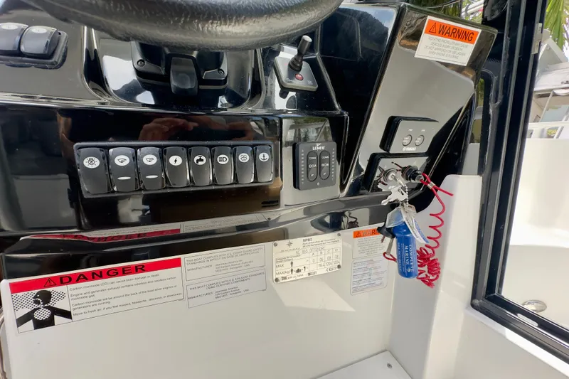 Slide: The Image of Control panel of a 2018 Jeanneau NC 895 boat with warning labels and ignition keys. - 23