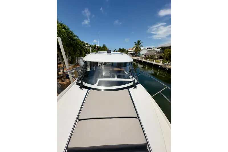 Slide: The Image of 2018 Jeanneau NC 895 boat docked by a canal under a clear blue sky. - 40
