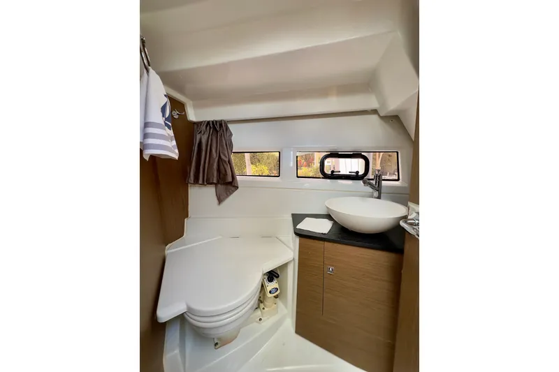 Slide: The Image of 2018 Jeanneau NC 895 boat bathroom with modern sink, compact toilet, and window. - 28