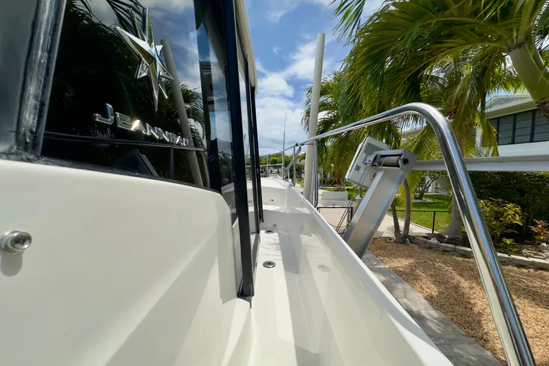 Slide: The Image of 2018 Jeanneau NC 895 boat side view with palm trees and clear sky. - 17