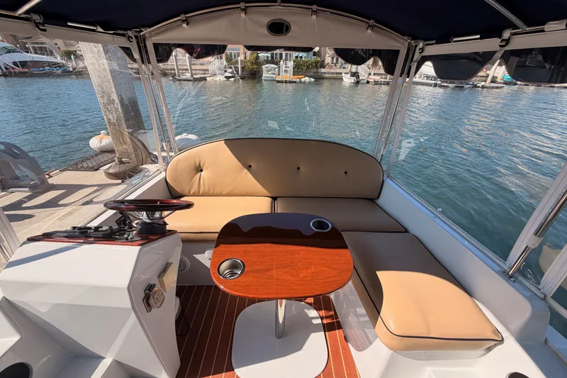 Slide: The Image of Interior of 2018 Duffy Cuddy Cabin 22 boat with seating and table, docked by the water. - 21
