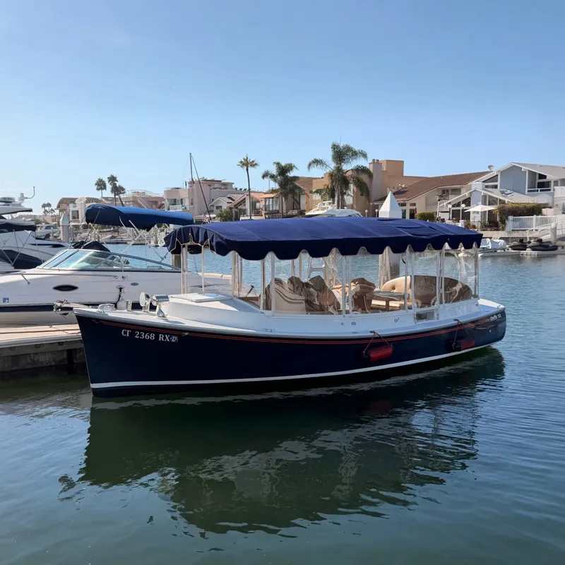 The Image of A 2018 Duffy Cuddy Cabin 22 is docked in the water. It features a blue canopy. - 0