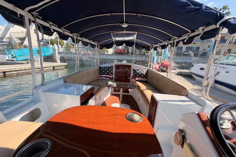 Slide: The Image of 2018 Duffy Cuddy Cabin 22 boat interior with seating, table, and canopy at marina. - 31