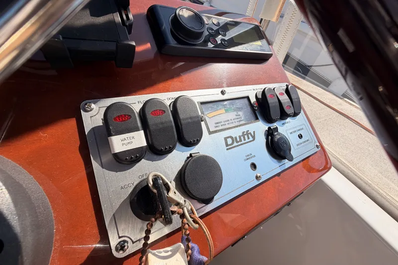 Slide: The Image of Control panel of a 2018 Duffy Cuddy Cabin 22 boat with switches and gauges. - 27