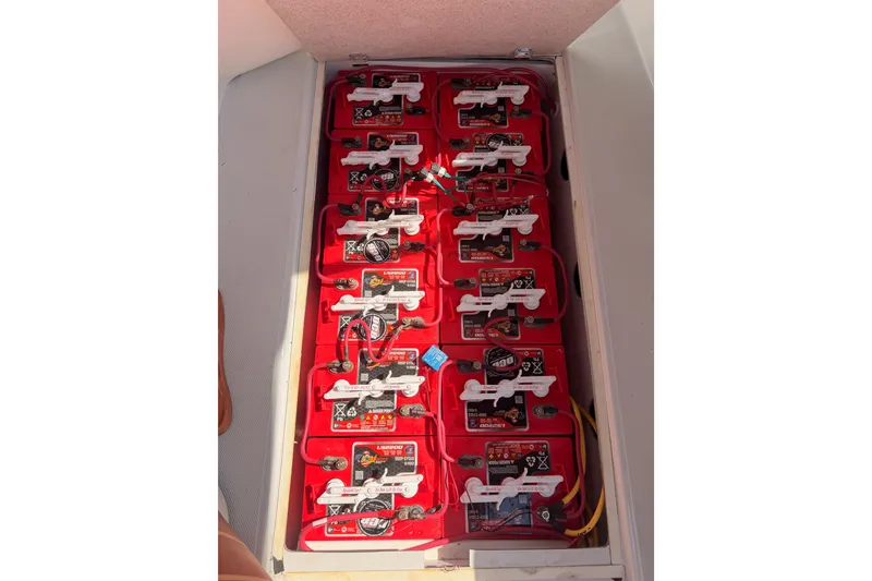 Slide: The Image of Battery compartment of a 2018 Duffy Cuddy Cabin 22 boat, featuring multiple red batteries. - 38