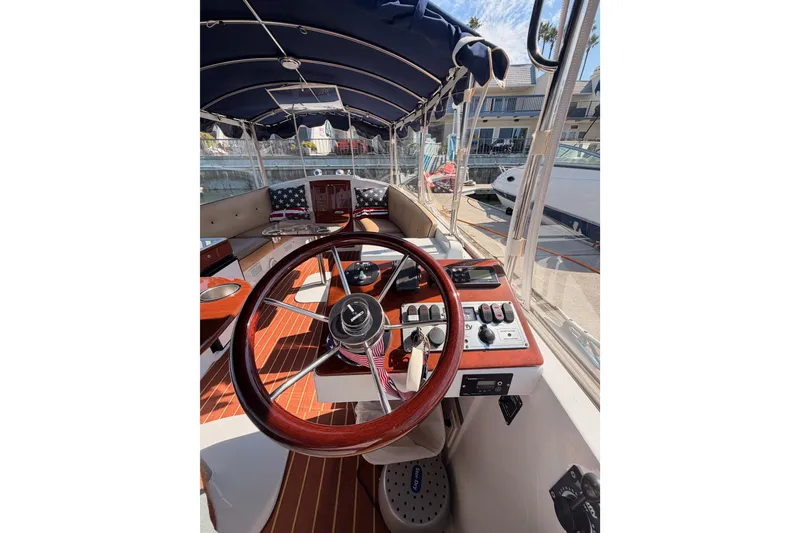 Slide: The Image of Interior view of a 2018 Duffy Cuddy Cabin 22 boat with steering wheel and controls. - 26