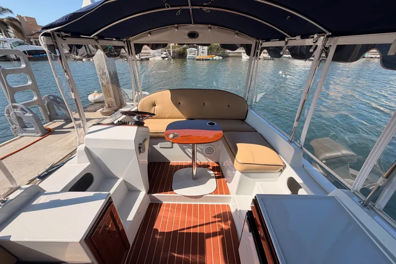 Slide: The Image of 2018 Duffy Cuddy Cabin 22 interior with seating and table, docked by the water. - 20