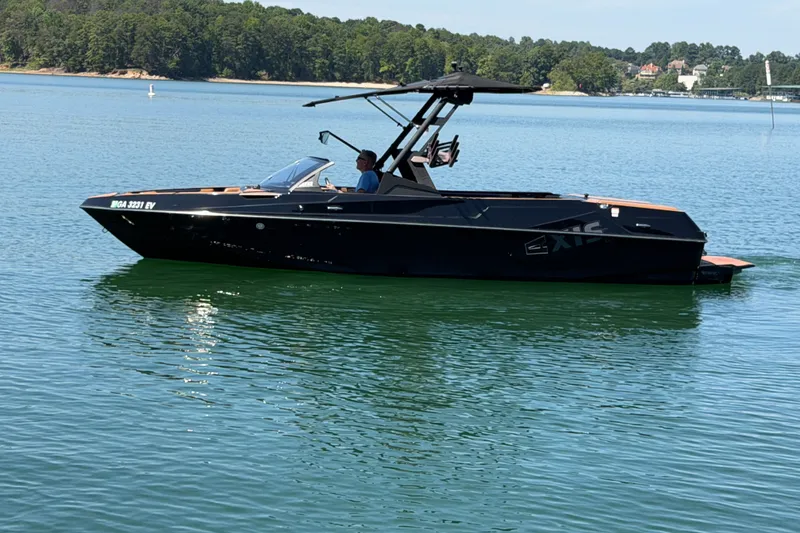 The Image of 2022 Axis T23 boat on a serene lake with lush green shoreline. - 0