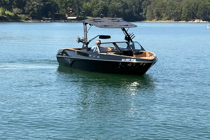 Slide: The Image of 2022 Axis T23 boat cruising on a serene lake with lush green shoreline. - 16