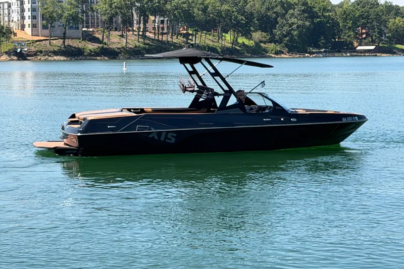 Slide: The Image of 2022 Axis T23 boat on a serene lake with trees in the background. - 8