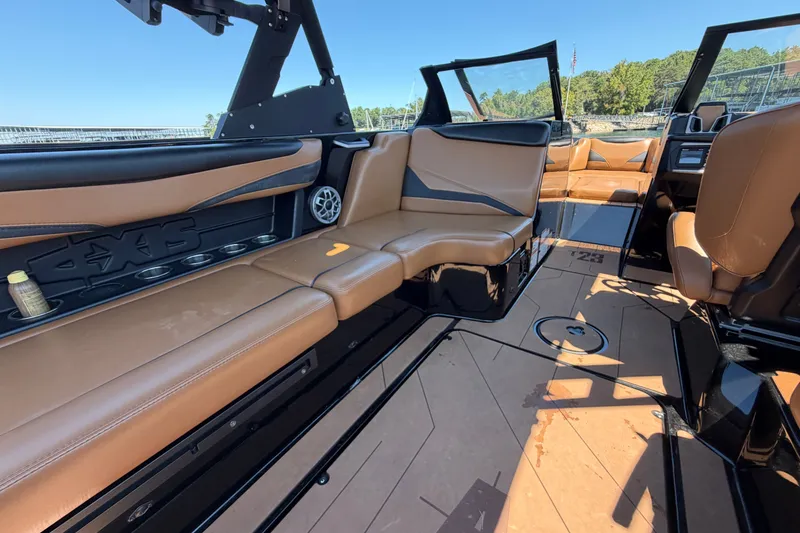 Slide: The Image of 2022 Axis T23 boat interior with tan leather seating and sleek black accents. - 24
