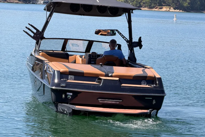 Slide: The Image of 2022 Axis T23 boat cruising on a serene lake with a person at the helm. - 4