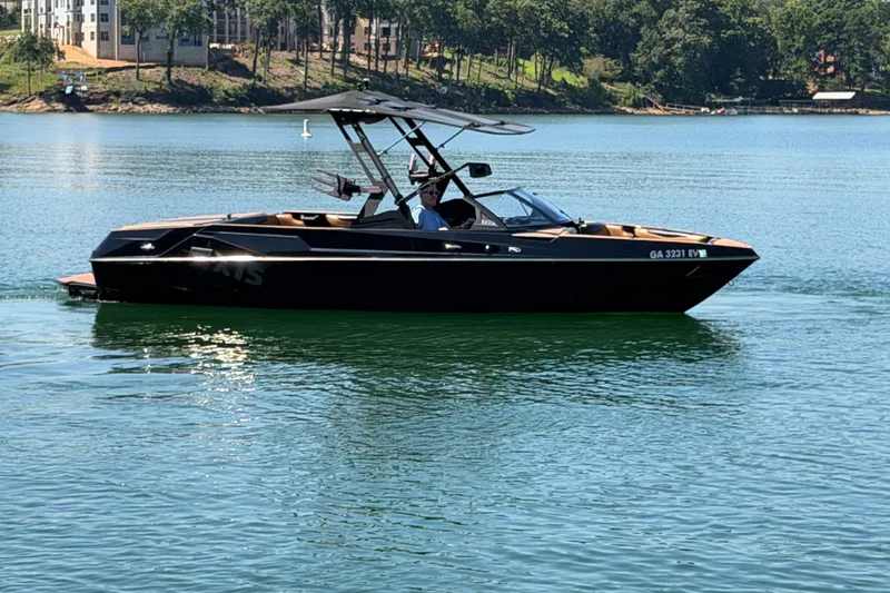 Slide: The Image of 2022 Axis T23 boat on a serene lake with lush green shoreline. - 10