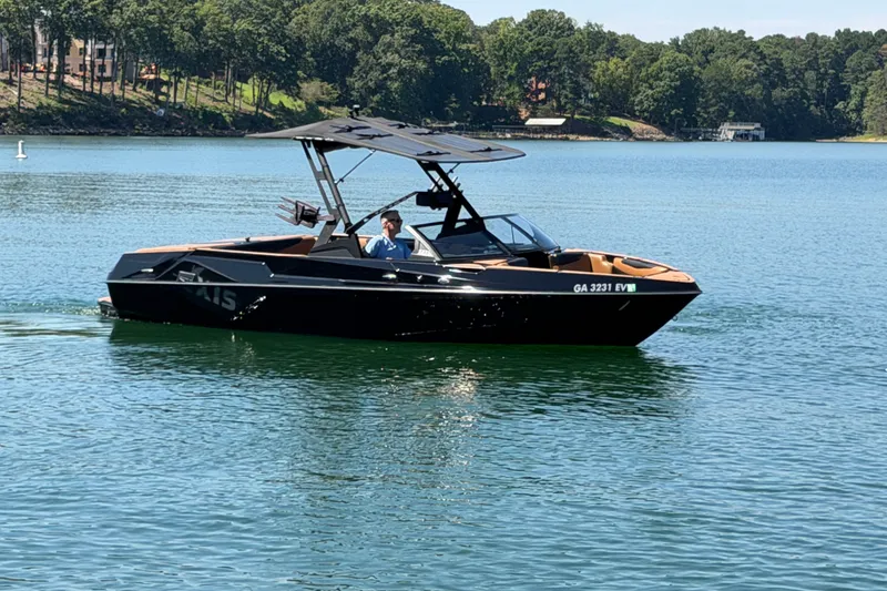Slide: The Image of 2022 Axis T23 boat cruising on a serene lake with lush green shoreline. - 13