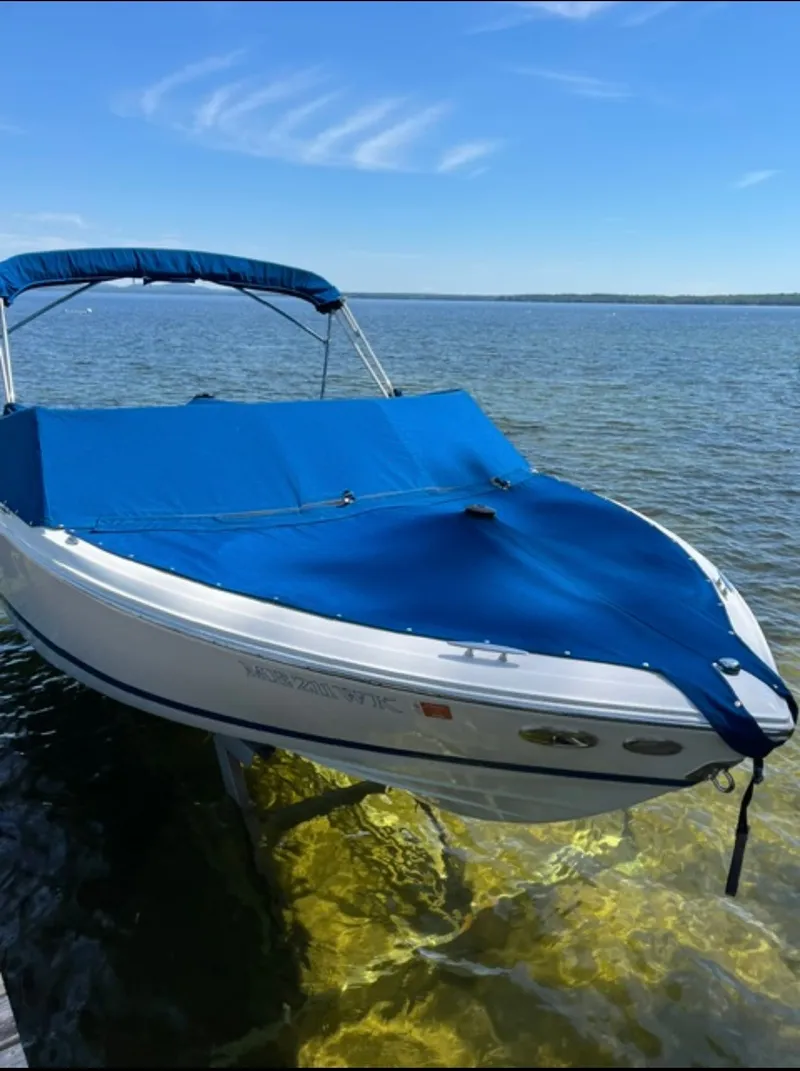 Slide: The Image of A 2017 Cobalt 200S boat with a blue cover on calm water. - 14