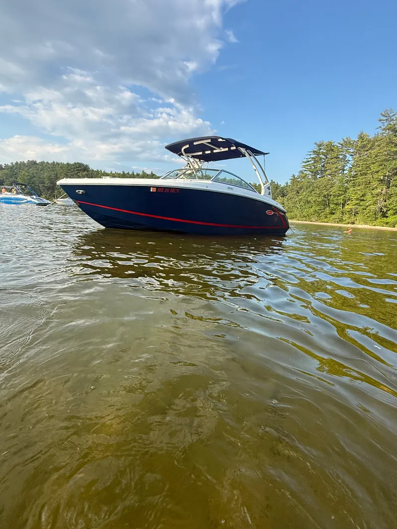 Slide: The Image of A 2021 Cobalt R3 boat floats on a calm lake with a wooded shoreline. - 6