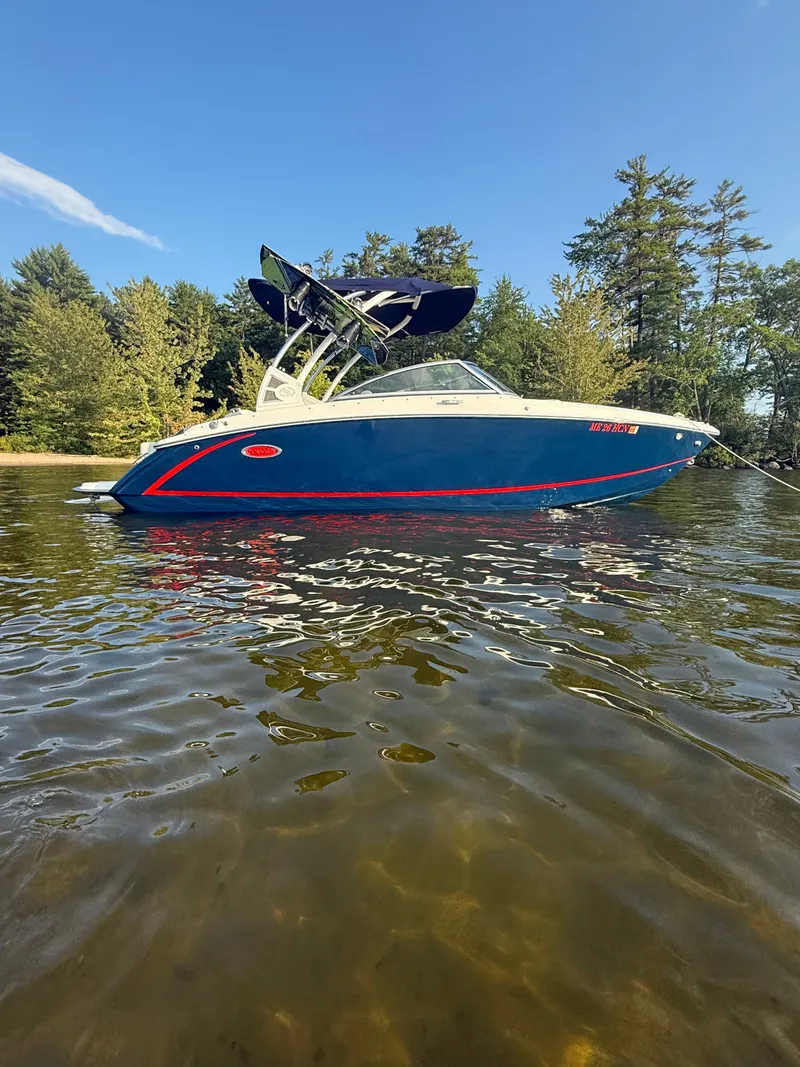 The Image of A blue 2021 Cobalt R3 boat floats on clear water, surrounded by trees. - 4