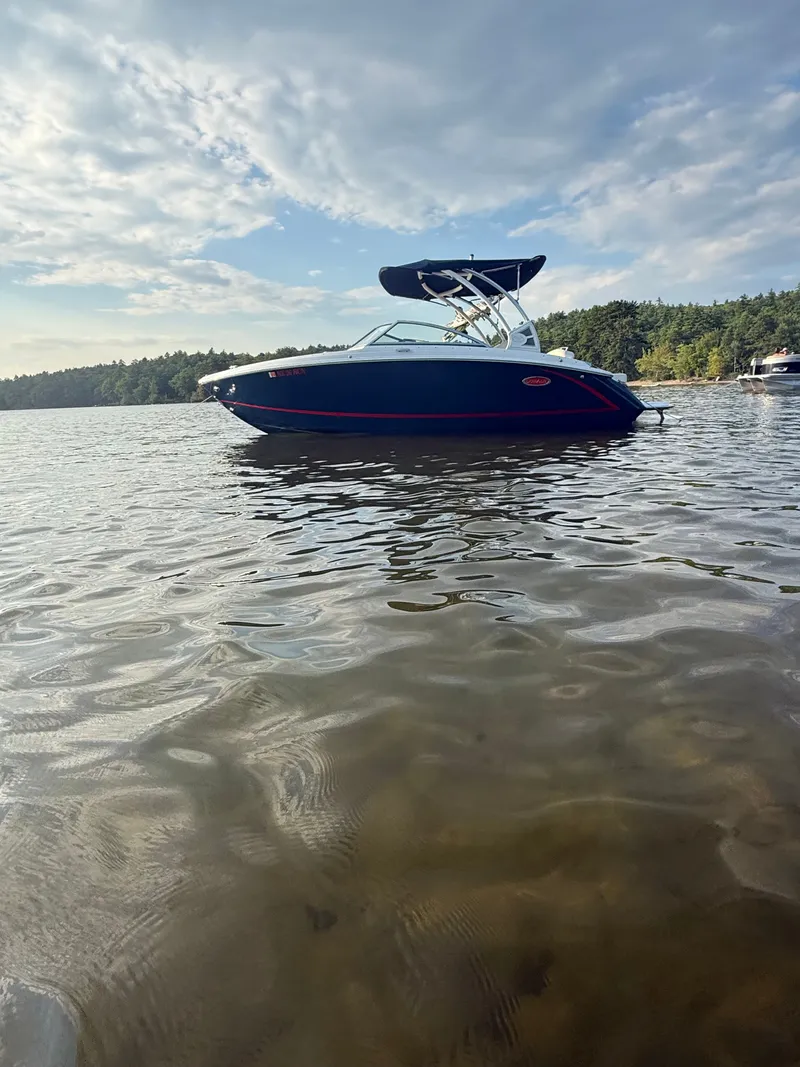The Image of A 2021 Cobalt R3 boat floats on a calm lake under a cloudy sky. - 1