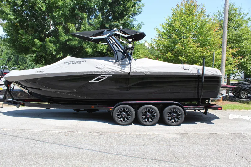 Slide: The Image of A black Centurion Ri 265 boat from 2022 is on a trailer, covered with a tarp. - 23