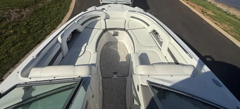 Slide: The Image of The image shows the bow area of a 2013 Chaparral 264 Sunesta boat with white cushioned seating. - 20