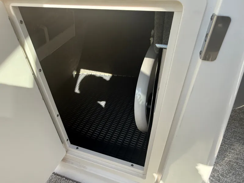 Slide: The Image of An open storage compartment with a grated floor in the Chaparral 264 Sunesta boat. - 23