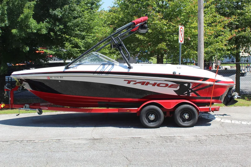 The Image of A red and white motorboat, Tracker TAHOE Q7I model, is on a trailer. - 1
