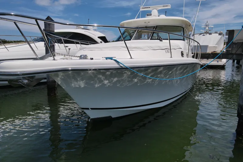 Slide: The Image of 2010 Pursuit OS 375 Offshore boat docked in marina under clear blue sky. - 15