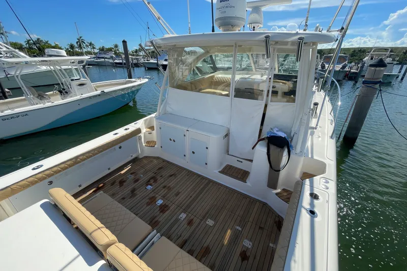 Slide: The Image of 2010 Pursuit OS 375 Offshore boat docked at marina, featuring spacious deck and seating. - 21
