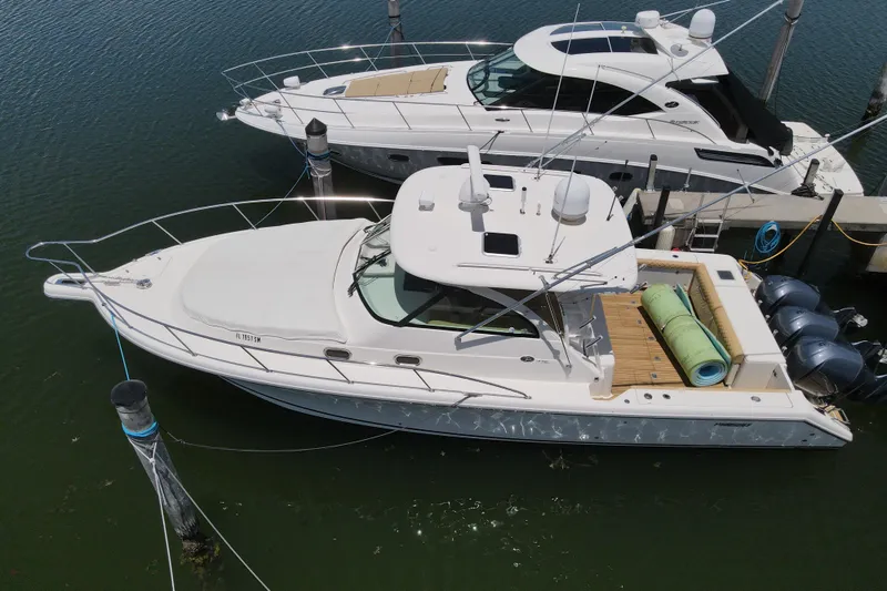 Slide: The Image of 2010 Pursuit OS 375 Offshore boat docked, aerial view, with twin engines and spacious deck. - 14