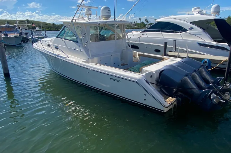 Slide: The Image of 2010 Pursuit OS 375 Offshore boat docked in a marina under clear blue skies. - 41