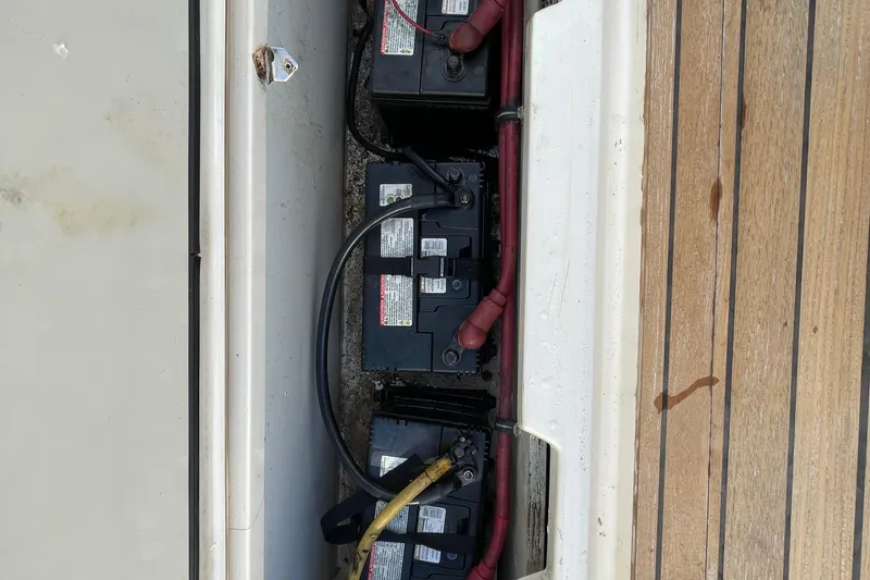Slide: The Image of Batteries in a 2010 Pursuit OS 375 Offshore boat compartment, with wooden deck. - 39