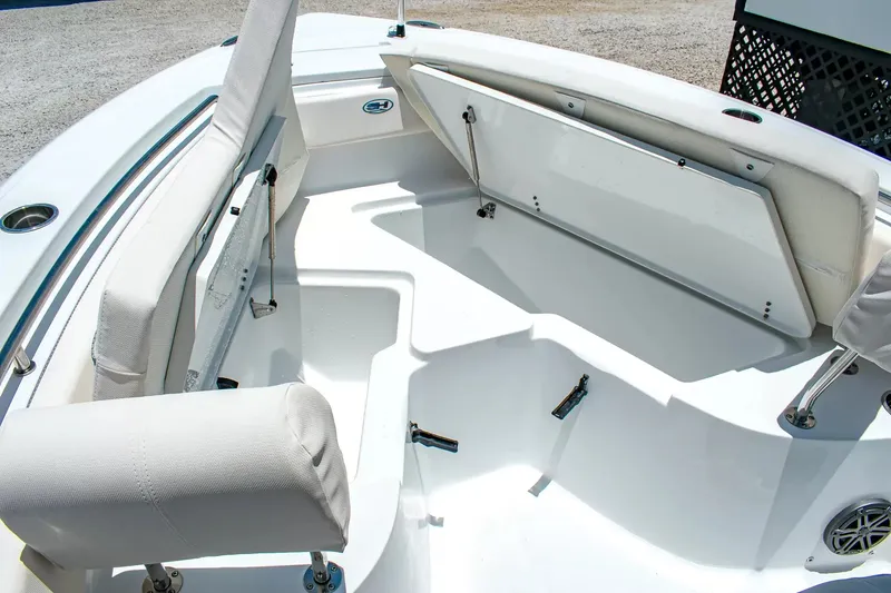 Slide: The Image of The image shows the bow area of a Sea Hunt Ultra 219 boat with white cushions and storage. - 22