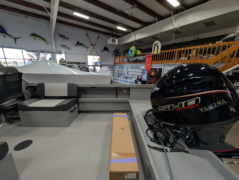 Slide: The Image of The image shows the interior of a Smoker Craft Phantom 20 X2 boat in a showroom. A Yamaha engine is visible. - 23