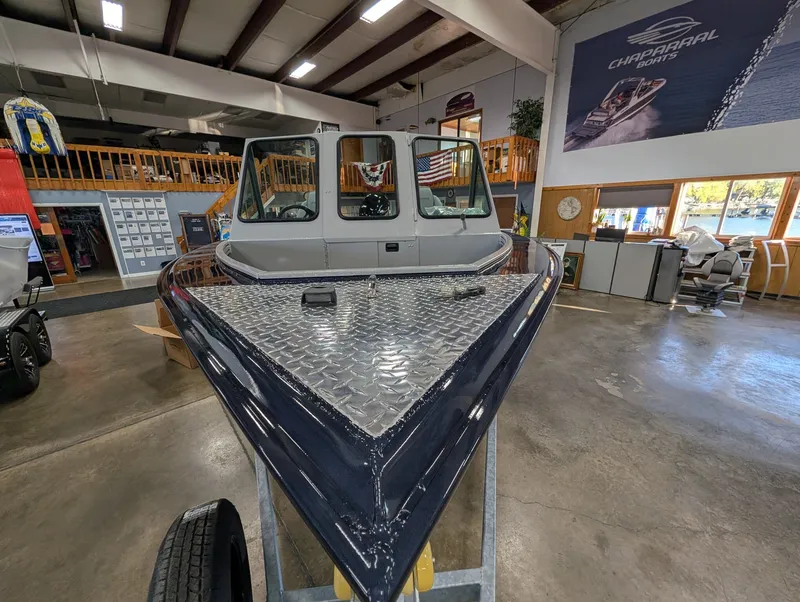 Slide: The Image of A 2026 Smoker Craft Phantom 20 X2 in a showroom. The bow is pointed and metal-clad. - 20