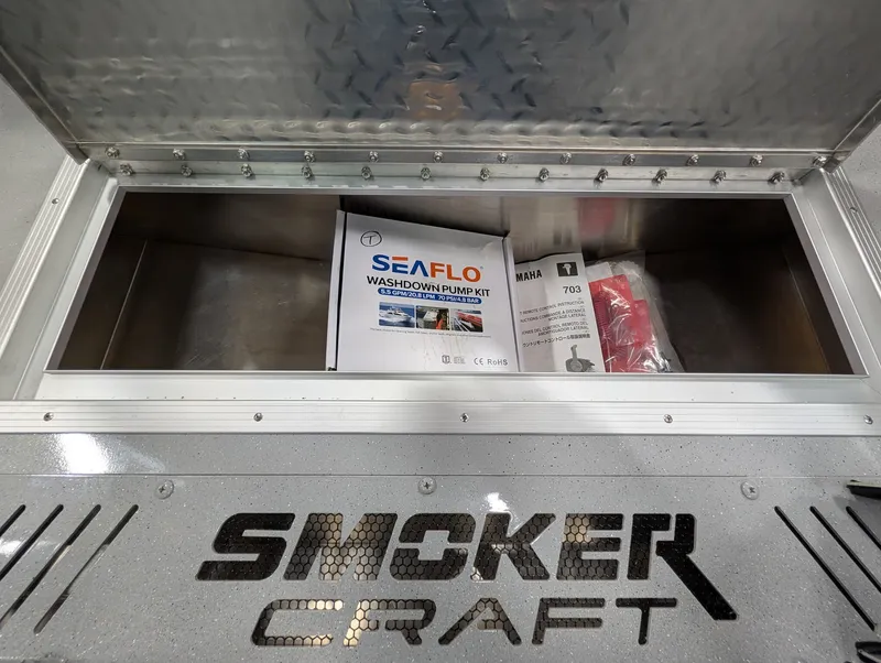Slide: The Image of An open storage compartment on a Smoker Craft boat reveals a Seaflo washdown kit and other items. - 32