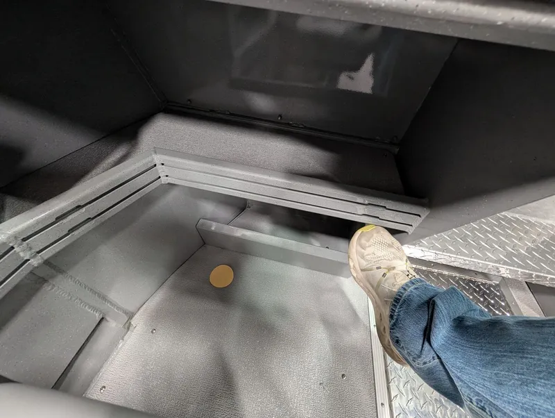 Slide: The Image of View of a boat's interior with gray flooring and a person wearing jeans. - 35
