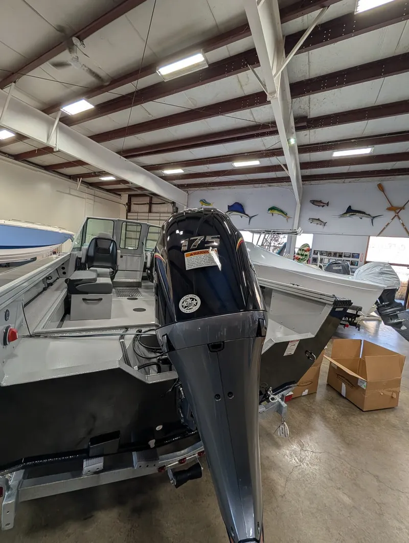 Slide: The Image of A Smoker Craft Phantom 20 X2 boat in a warehouse, featuring a powerful outboard motor. - 17