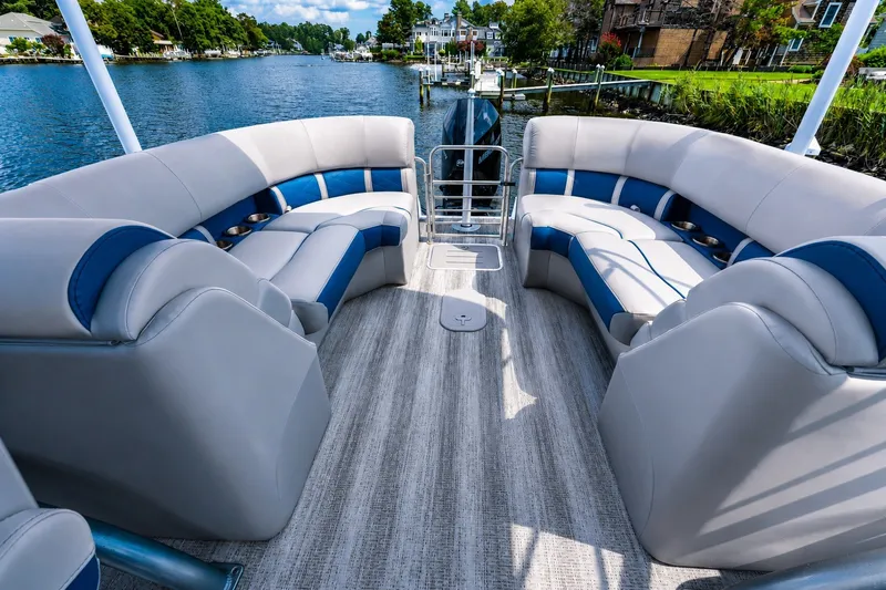 Slide: The Image of Luxurious 2022 Bennington L 24 Quad Bench pontoon boat interior with plush seating and scenic waterway view. - 6