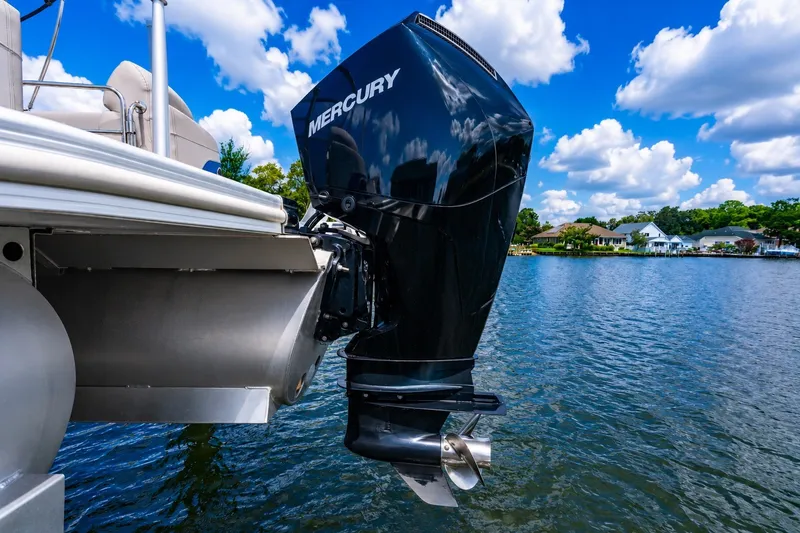 Slide: The Image of 2022 Bennington L 24 Quad Bench with Mercury outboard motor on a lake. - 13