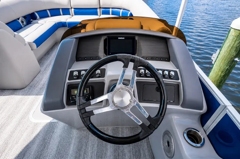 Slide: The Image of 2022 Bennington L 24 Quad Bench boat dashboard with steering wheel and controls. - 8