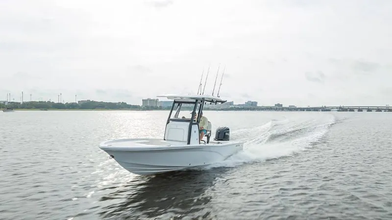 The Image of A 2027 Sea Fox 251 Bay Fox speeds across calm water, with a cityscape in the background. - 1