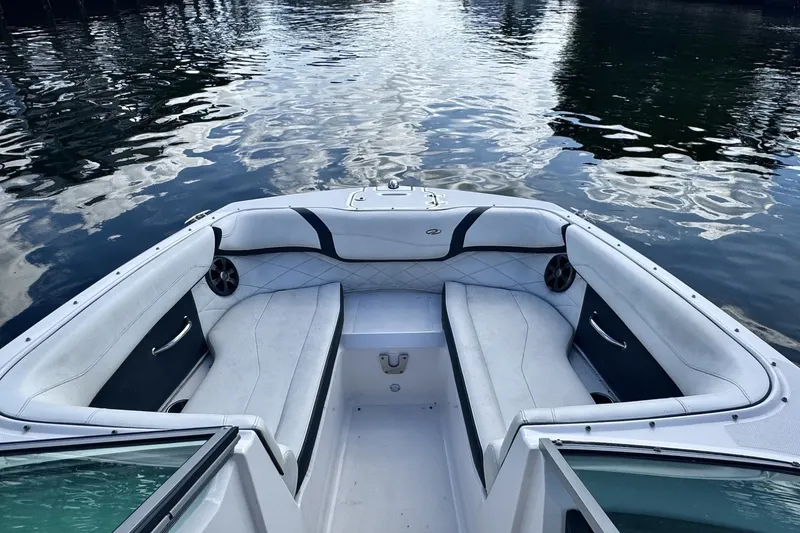 Slide: The Image of 2018 Regal 23 OBX boat interior with white seating, on calm water. - 6