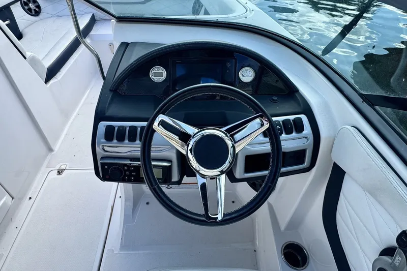 Slide: The Image of Steering wheel and dashboard of 2018 Regal 23 OBX boat, docked by water. - 5