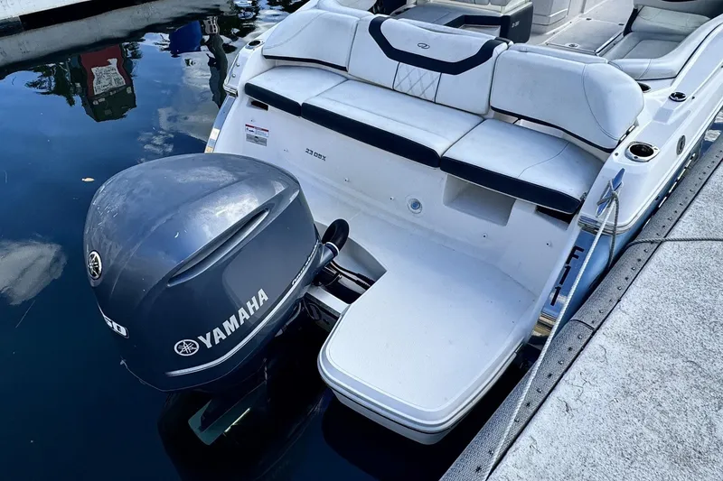 Slide: The Image of 2018 Regal 23 OBX boat with Yamaha outboard motor docked by the water. - 1