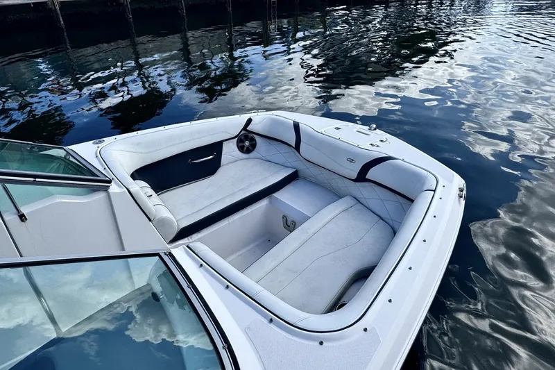 Slide: The Image of 2018 Regal 23 OBX boat interior with white seating on calm water. - 2